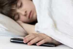 girl with hand on mobile cell as she sleeps
